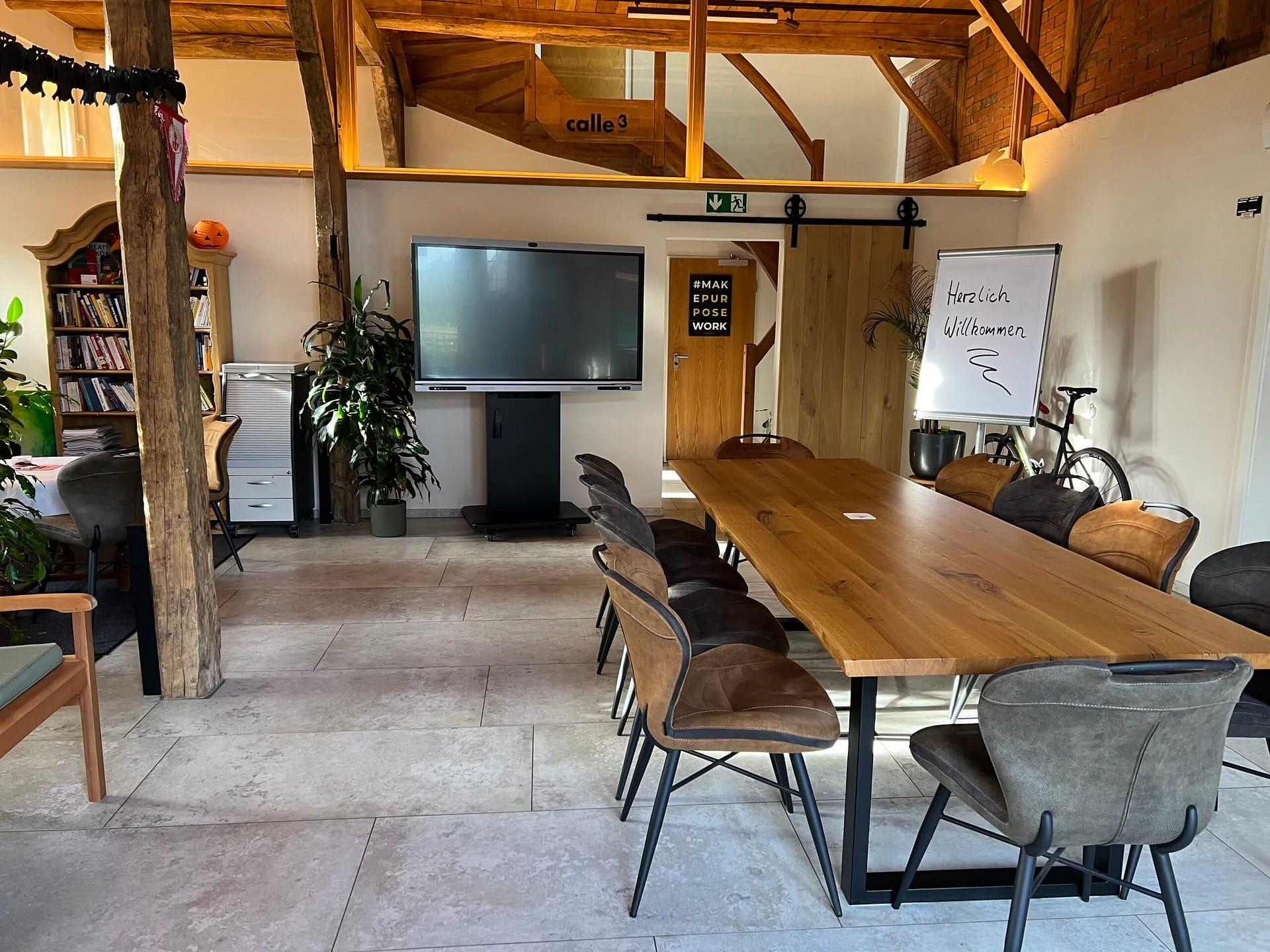 Großer Holztisch in der Tenne – Setup für ca. 10 Personen mit Präsentationsfläche